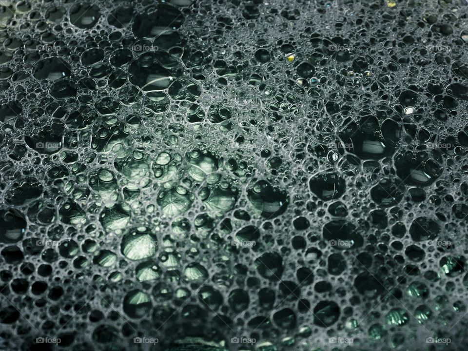 Close-up shot of washing liquid bubbles in a glass bowl