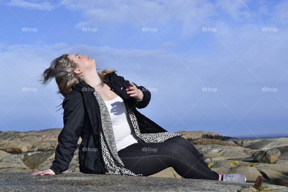 Woman sitting on rocky mountain