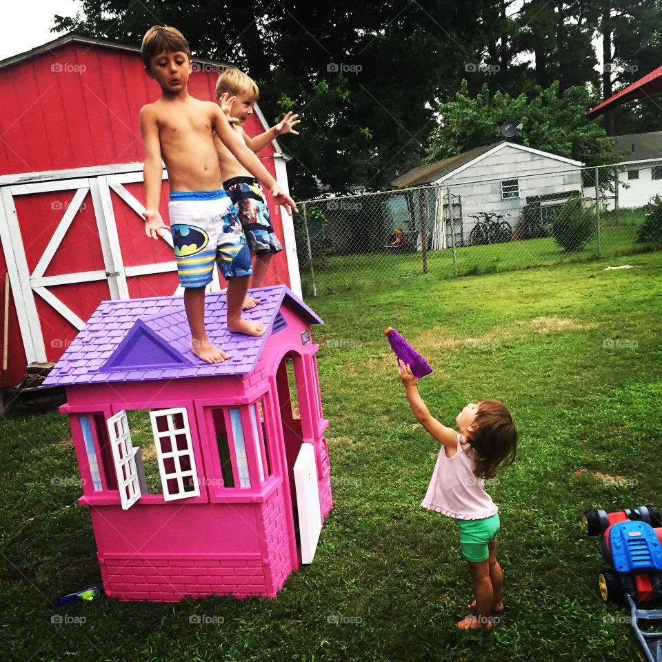 Brothers and sister playing with toy house