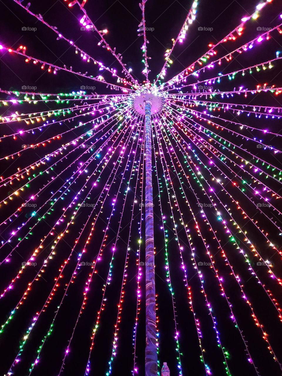 Upward view of colorful LED lights at a festival.