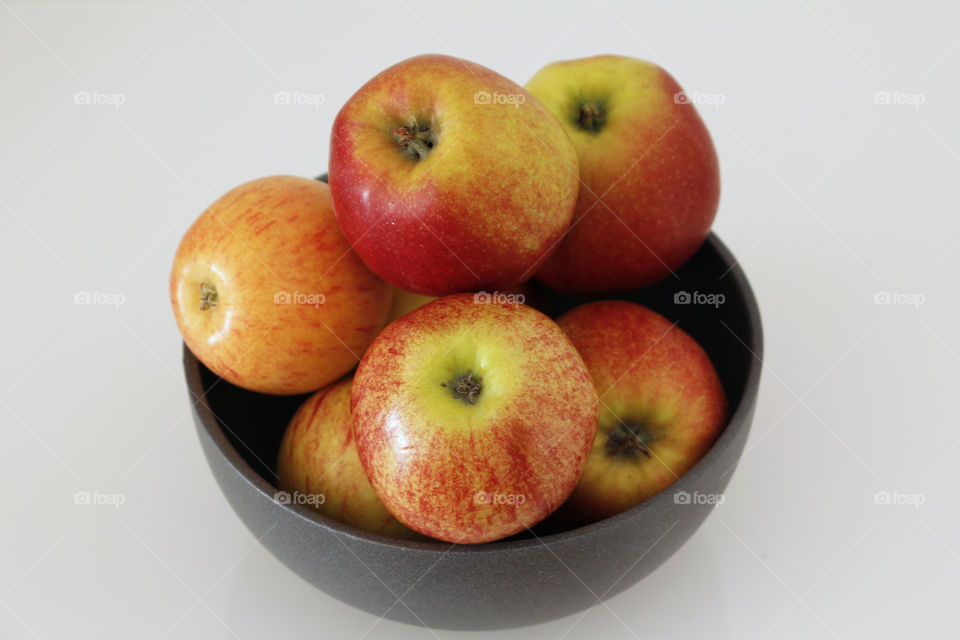 Red yellow apples in grey bowl 