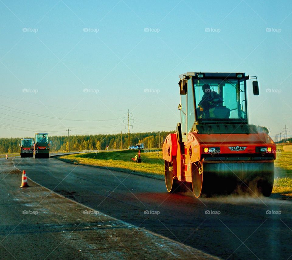 Large road roller paving road
