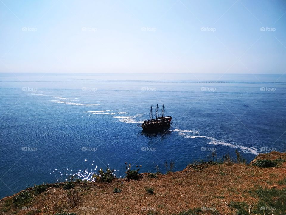 A beautiful blue colour sea view with a ship floating on.