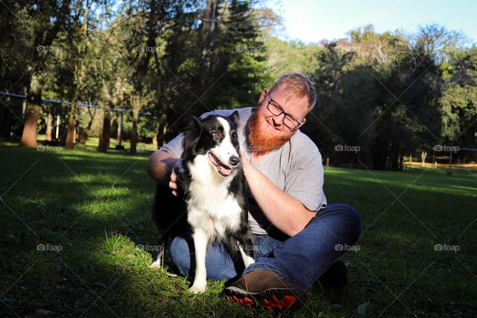 Homem, adulto, loiro, barbudo, com seu cachorro.