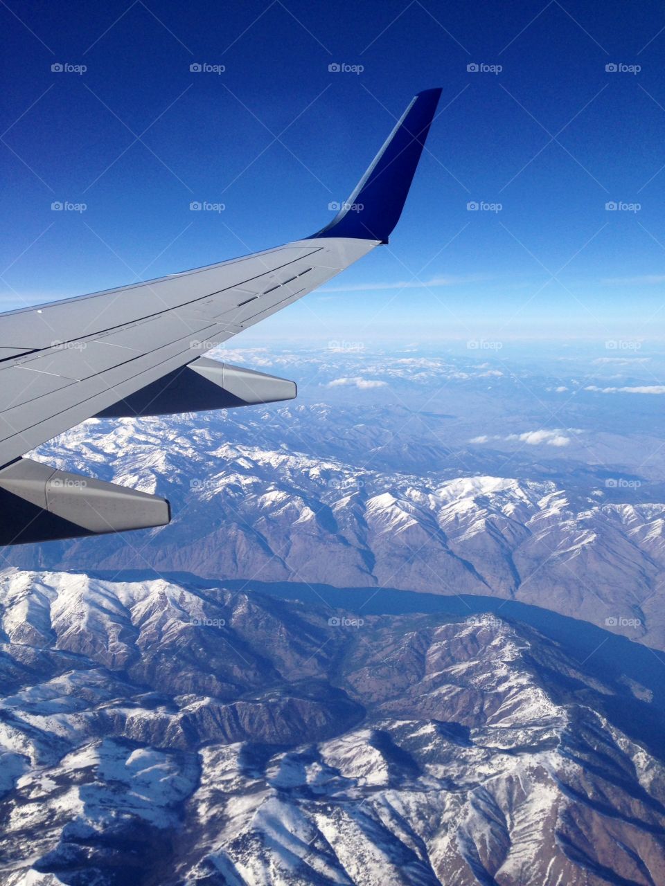 Airplane flying over mountains during winter