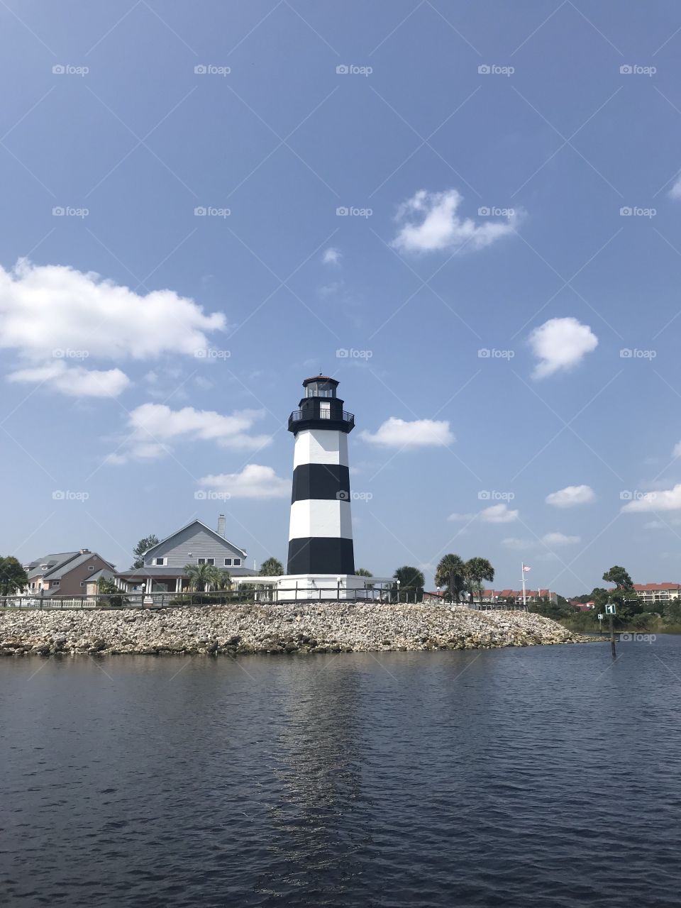 A gorgeous summer day at the Little River marina in between South and North Carolina. The cute lighthouse stands out among the smaller structures nearby.