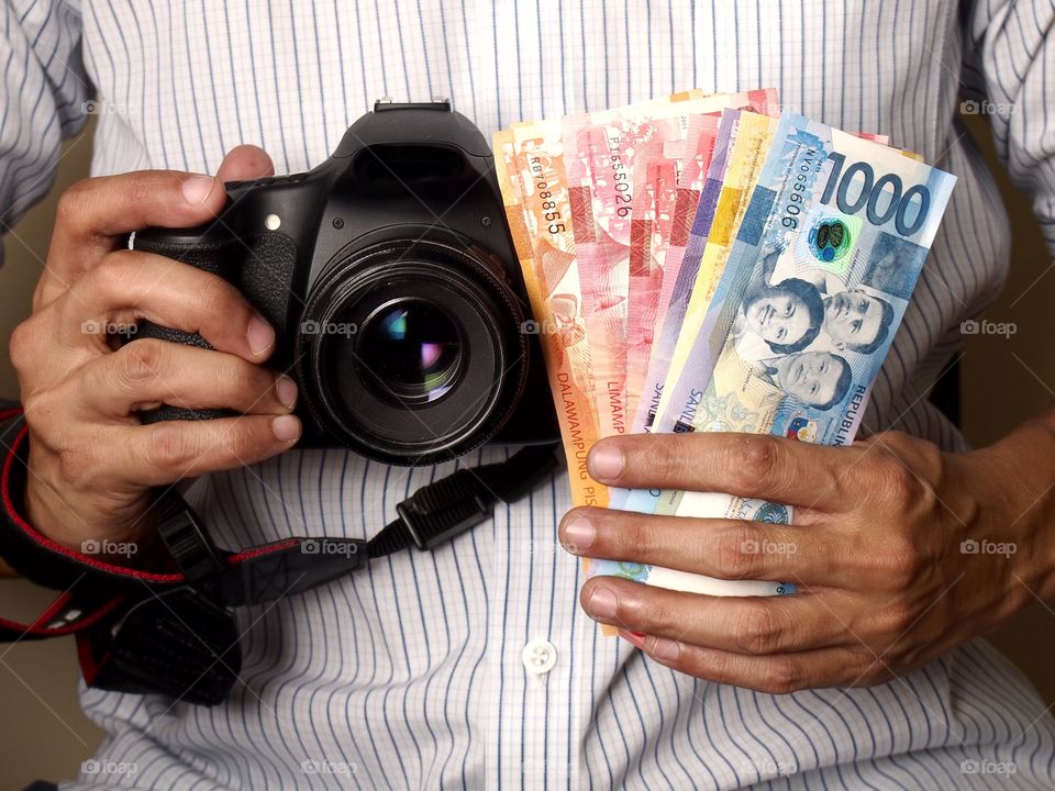 man holding a camera and money. man holding a camera and bills of money