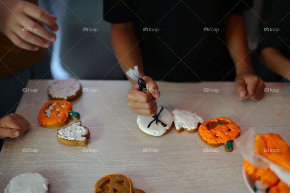 seven year old boy decorating handmade cookies for Halloween