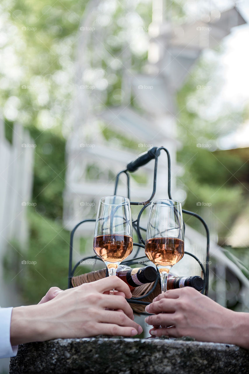 Close-up of bride and groom's hand with wineglass