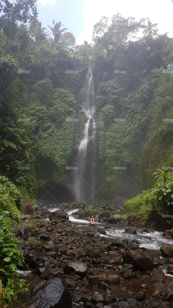 meditating by a magnificent waterfall in bali
