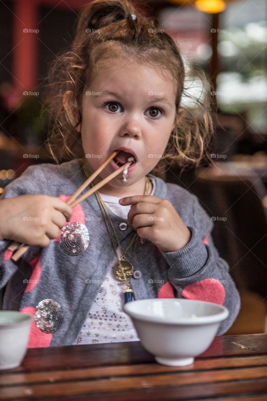 Girl eating food with chopstick