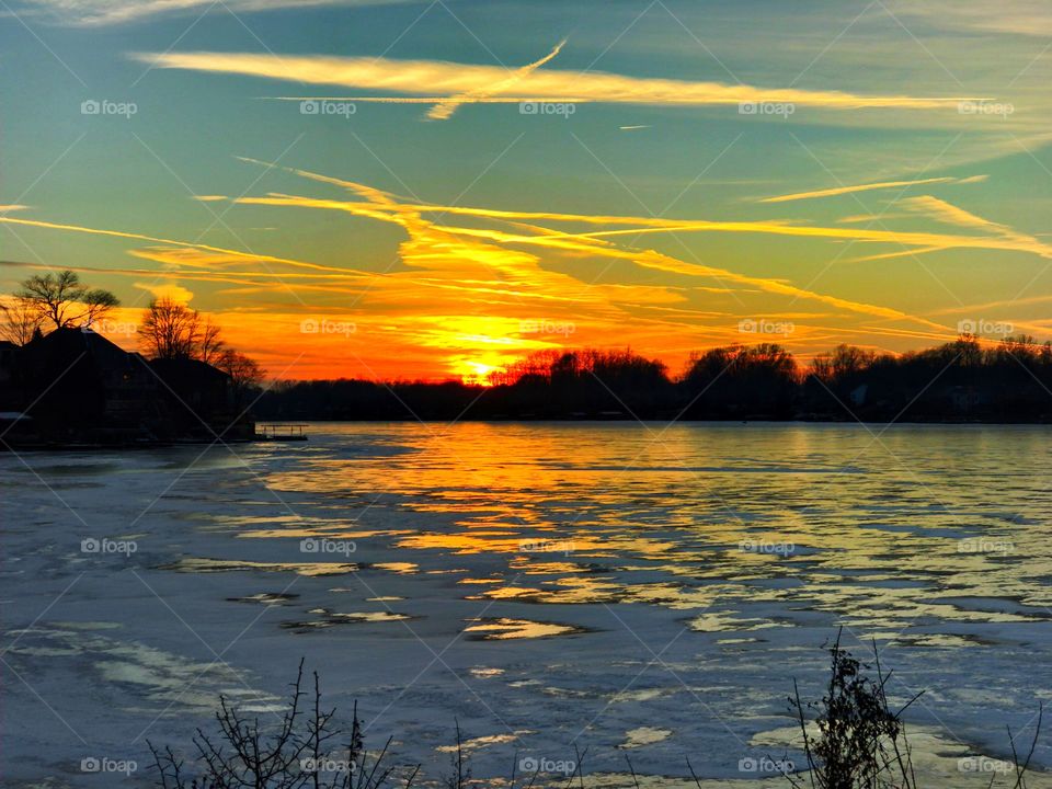 Sunset on the lake that is frozen. 