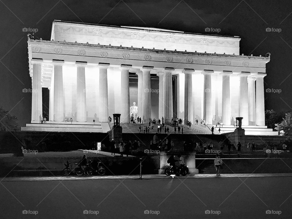 The Lincoln Memorial glows at night as it sits elevated over the surrounding area