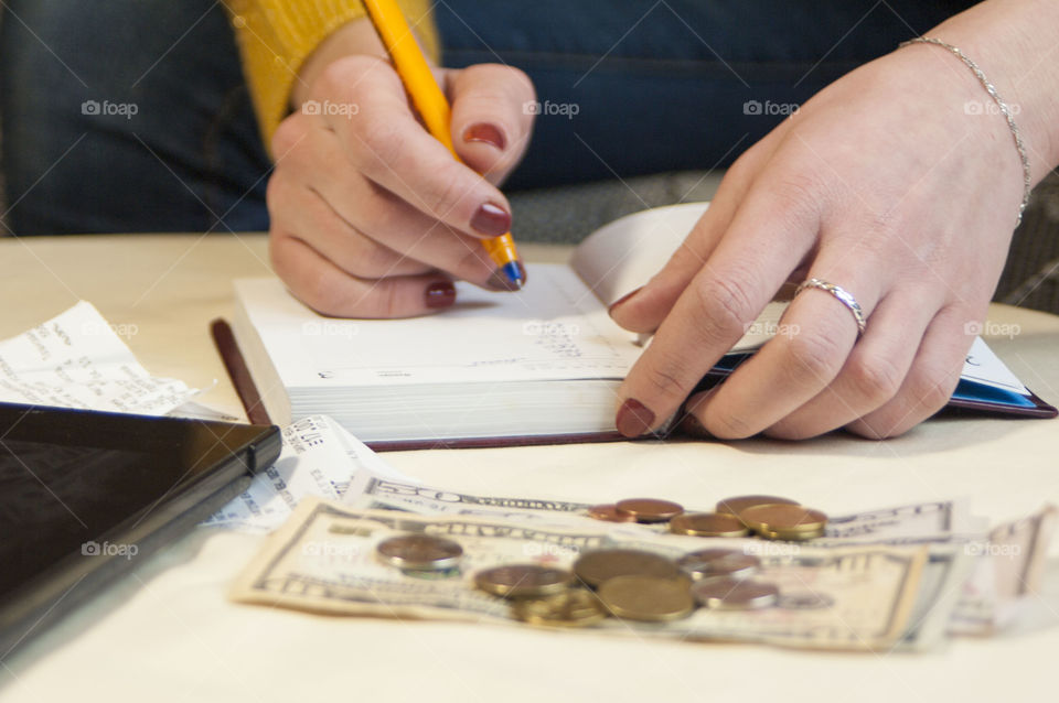 girl does records in a notebook, counting finances