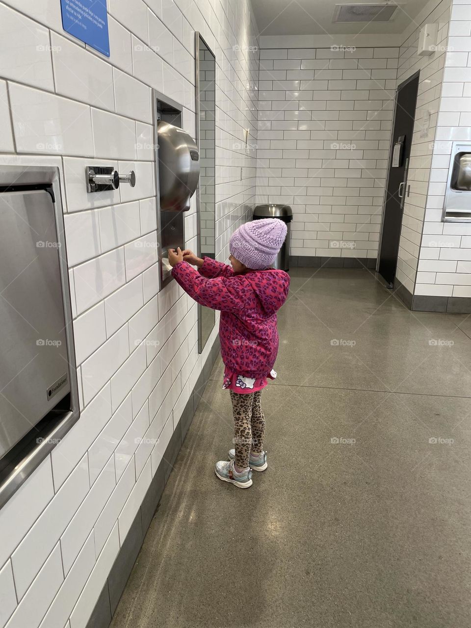 Little girl dries her hands in the restroom, using public restrooms with kids, drying hands with air dryers, using Walmart restrooms