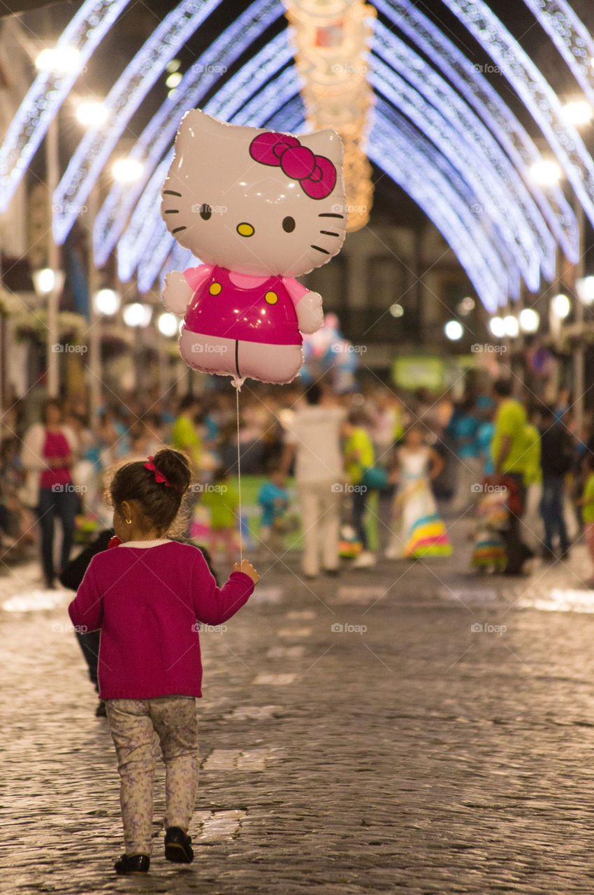 Child walking with hello kitty balloon