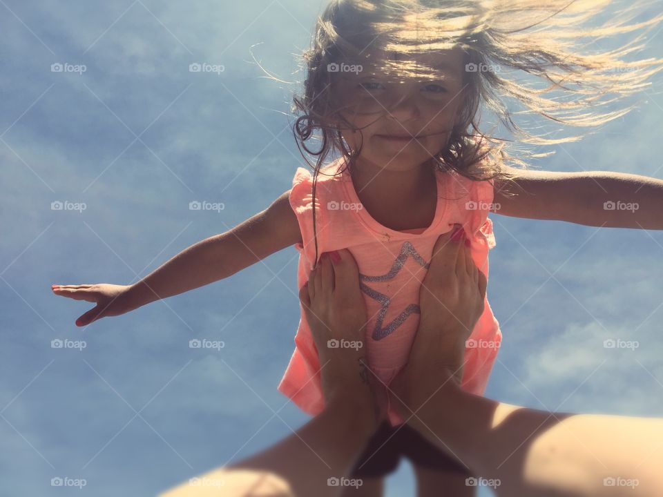 Girl balancing on mother's leg