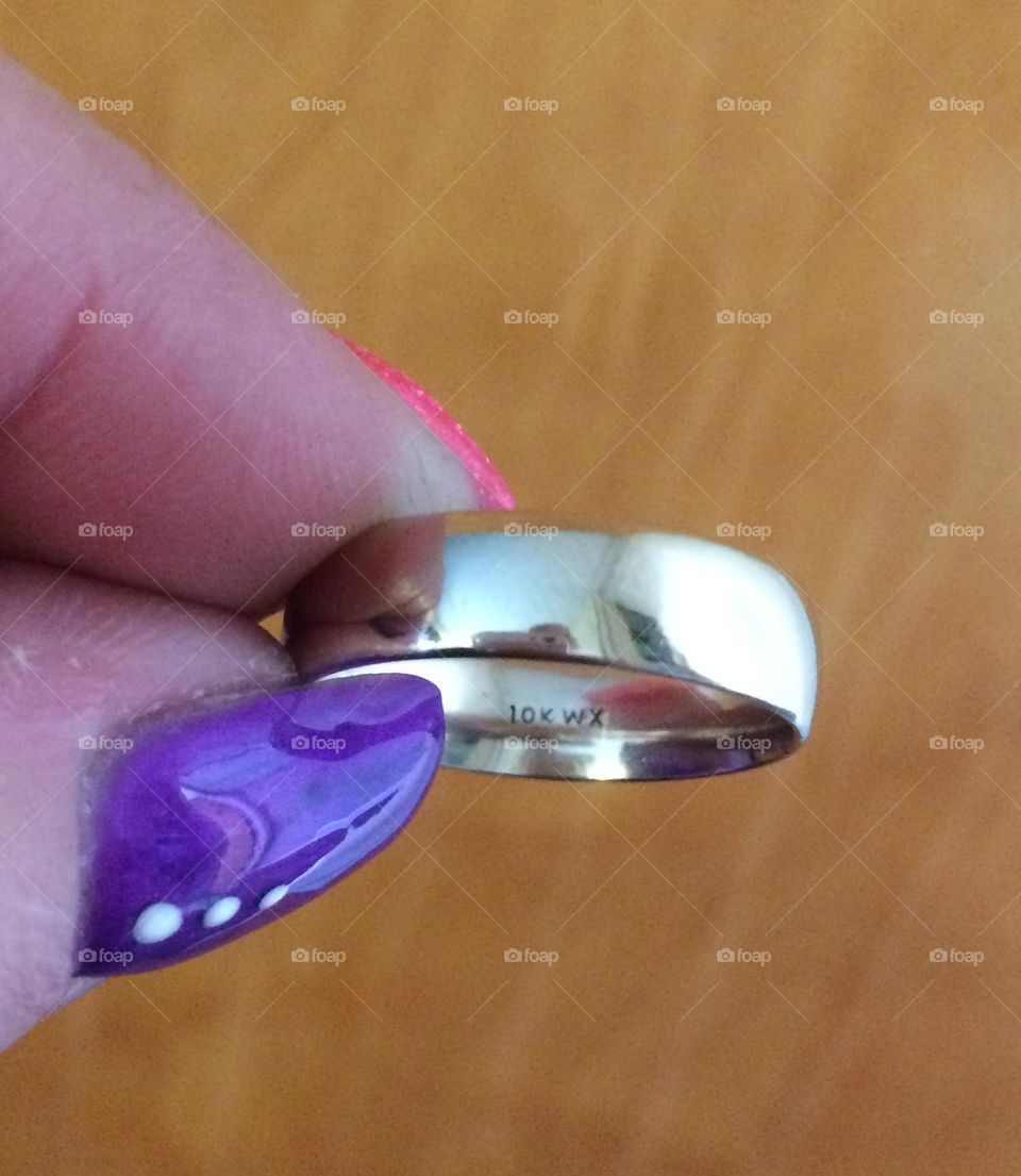 My favorite metal is this 10 carat white gold wedding band, engraved stamp inside, showing off my newly manicured thumb and pointer fingers, and reflections with a wood table background