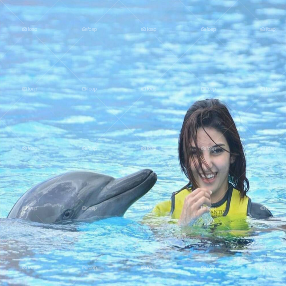 Woman with dolphin in swimming pool