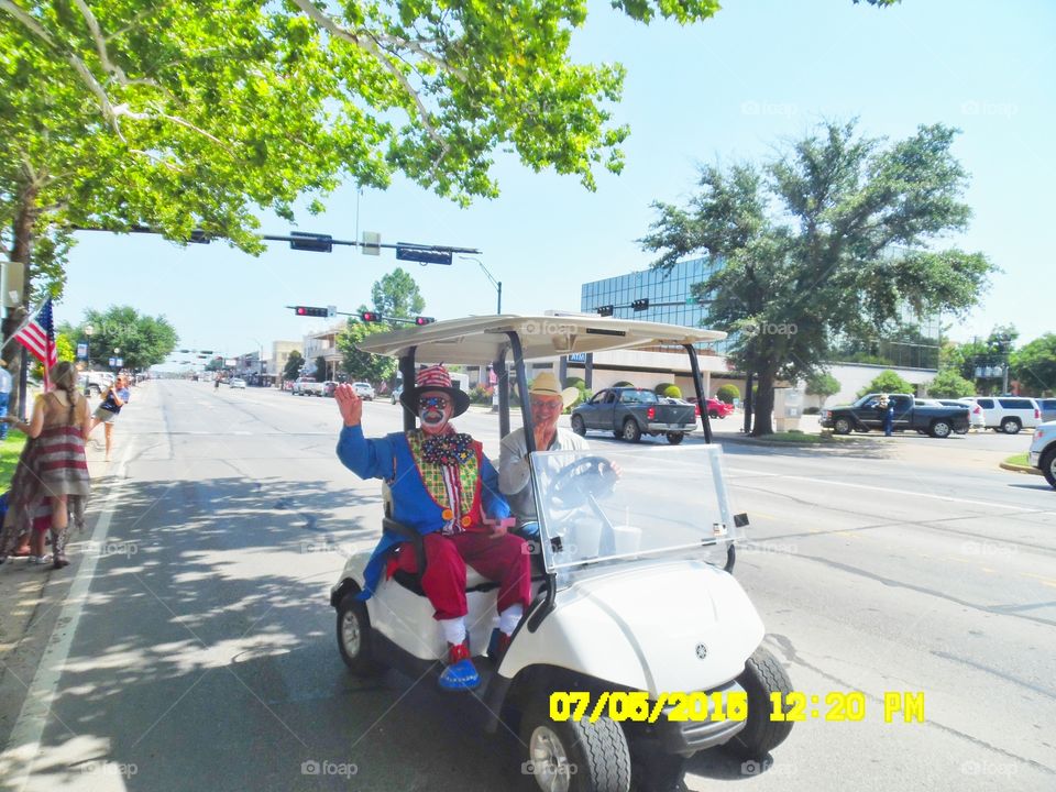 flag throwing clown. This clown in the golf car 🚗 was riding with the parade and handing out flags 🎌