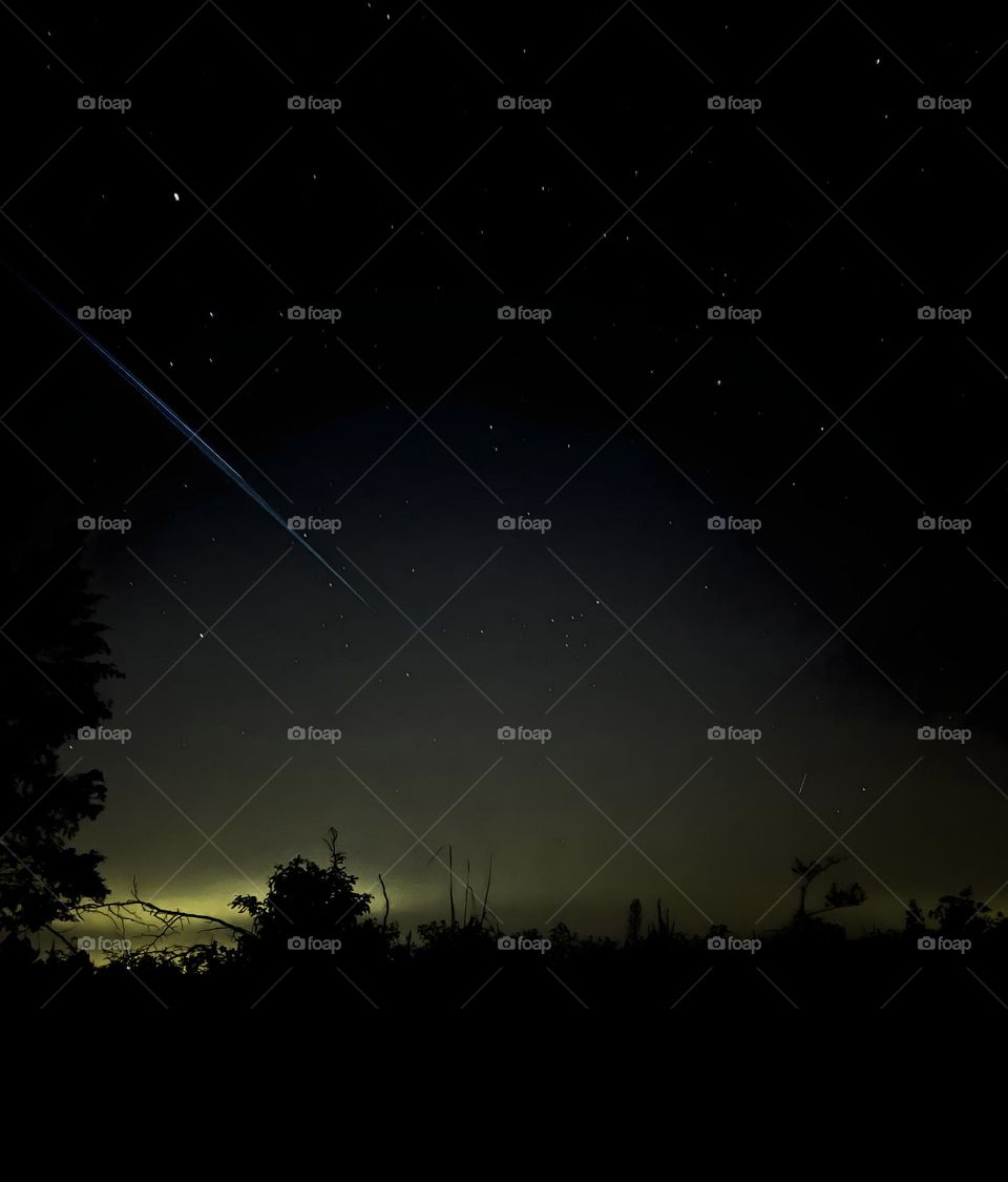 Starlink train passing through the sky with a small meteor to the right.