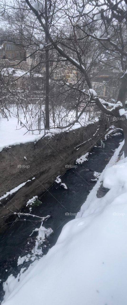 Winter and its snowy days is not cold 
for real lovers , as long as the warm memories of  loved ones are with them .
A frame of the winter snow , runnel , trees and village houses covered with snow .