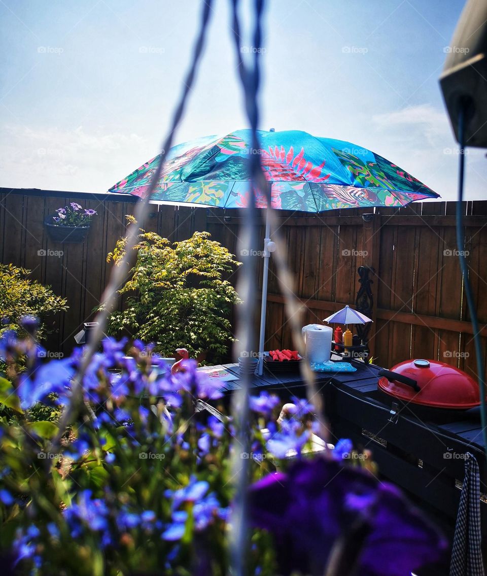 Garden barbieque through a basket of flowers