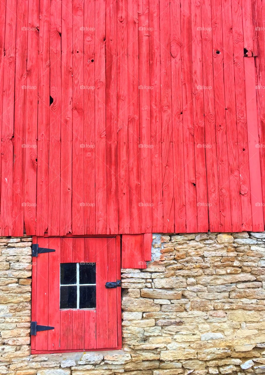 Red side of a barn leads into a stone wall color pop