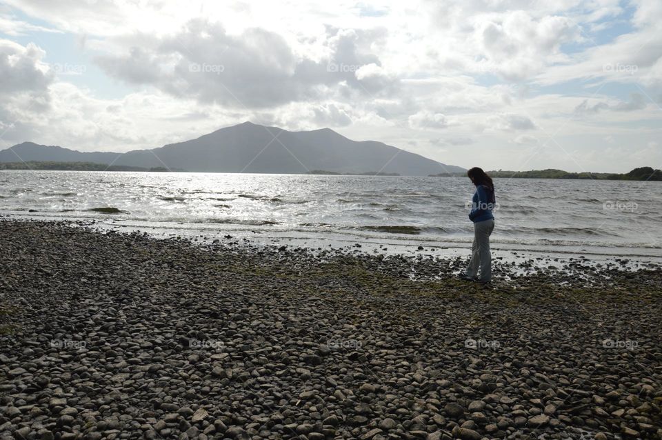 woman walking alone at the edge of the lake