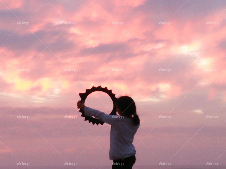 little girl try to catch sunset.