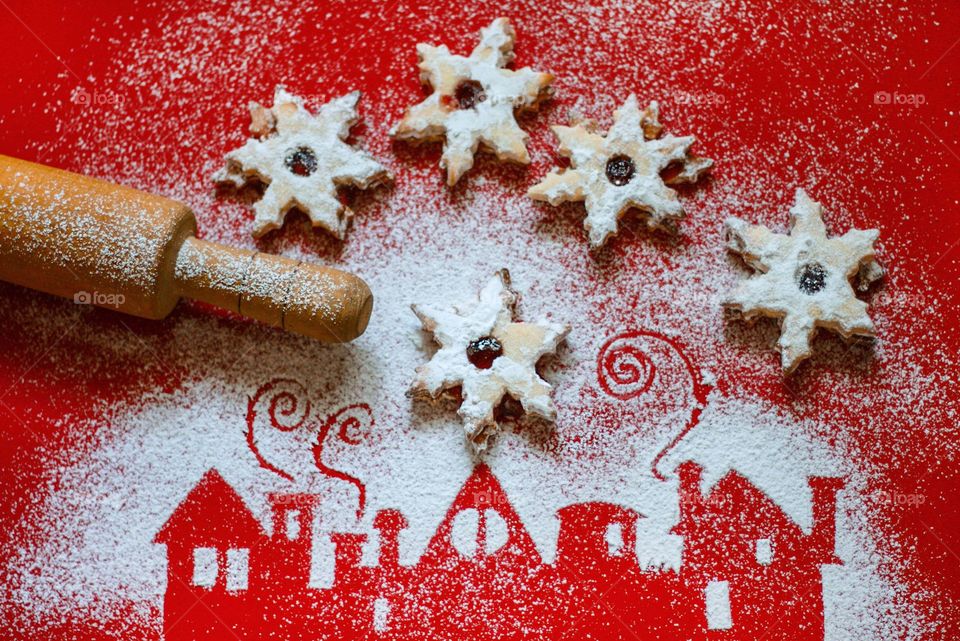 Rolling pin, Christmas cookies, powdered sugar, silhouettes of houses on red background