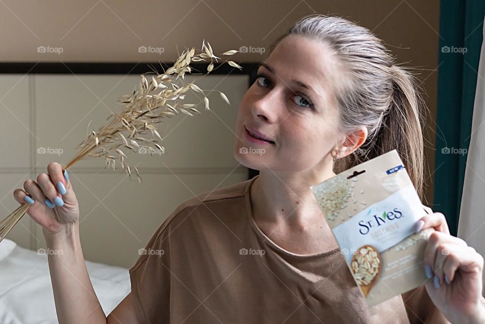 young girl with cosmetics product in her hands, face mask brand St. Ives. Personal care