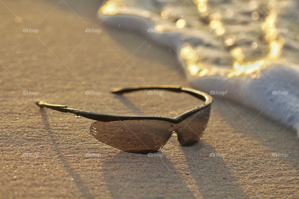 sunglasses under wet sand