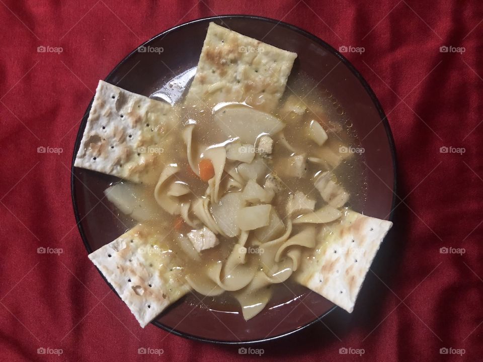 Angry Homemade Chicken No Yolks Noodles Soup with Carrots, potatoes and Saltless Saltines. 