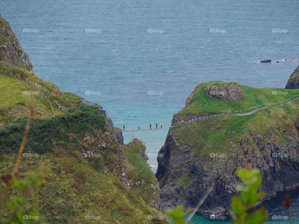 Tourist crossing the Carrick-a-Rede rope bridge in Antrim, Northern Ireland