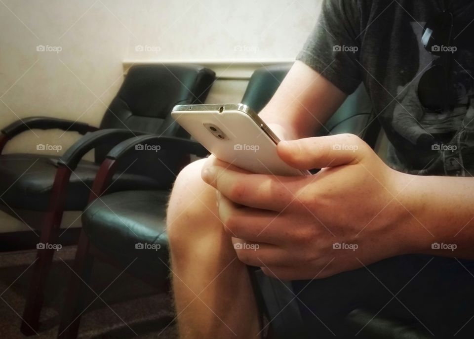 A man's hands holding the favorite gadget for helping you wait a smartphone