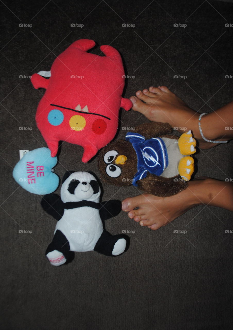 My feet and some stuffed animals on the floor