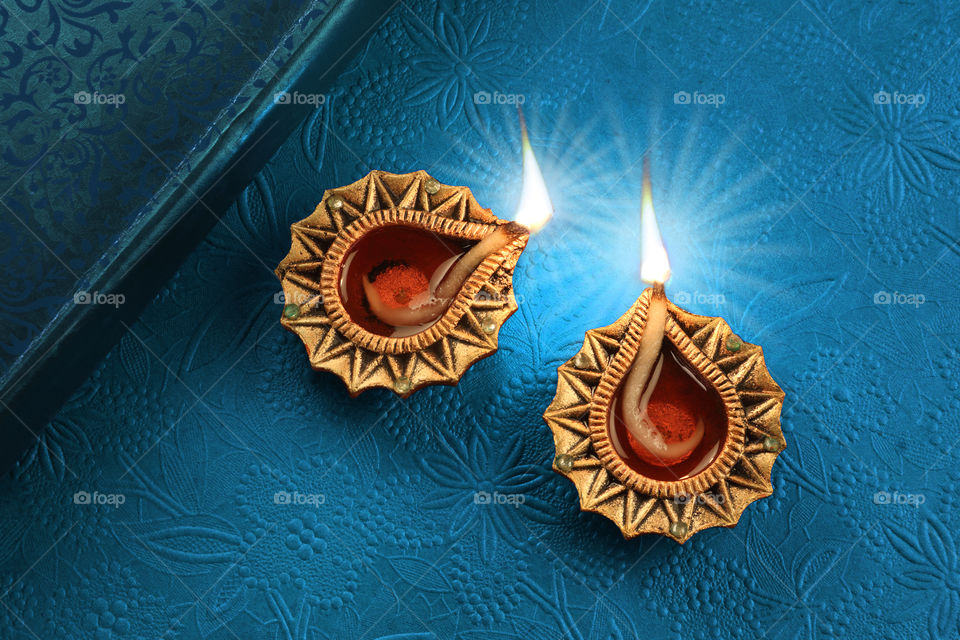 Golden Diwali Diya on blue textured background