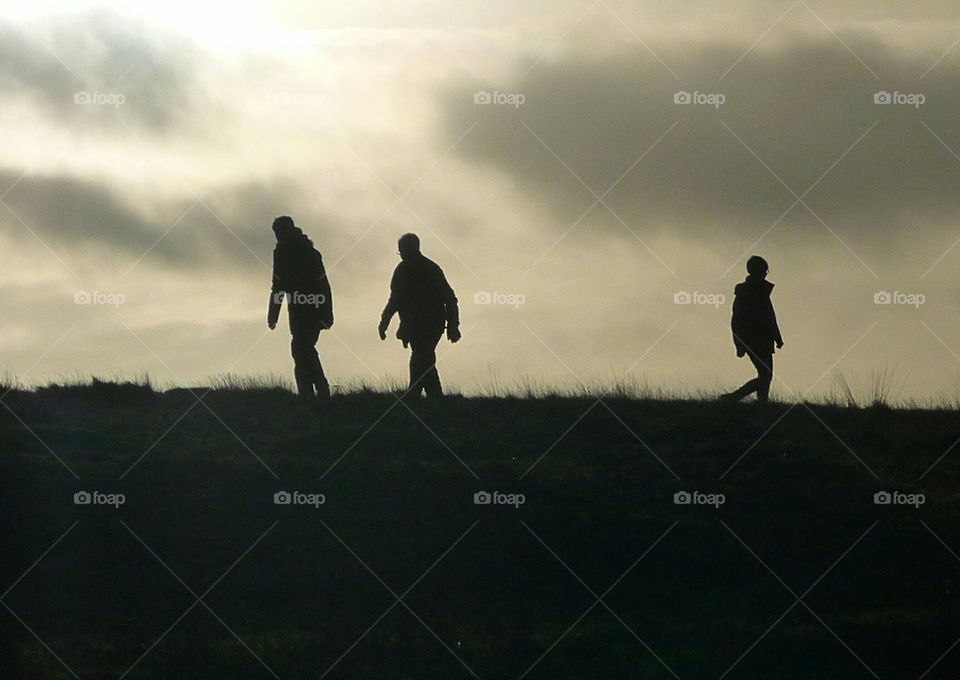 hill walkers at sunset