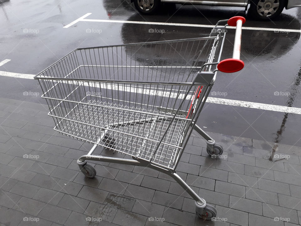 Carts for grocery products stand near a supermarket on the street