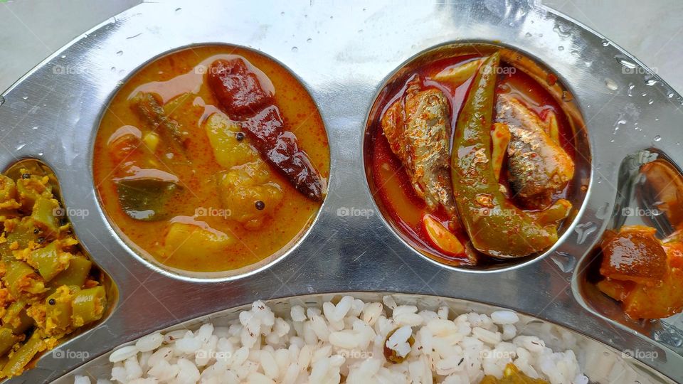 Sambar and fish curry, spicy curry from India,  Indian vegetarian and non-vegetarian curry, food from India, Thoran(left end) and lemon pickle (right end)