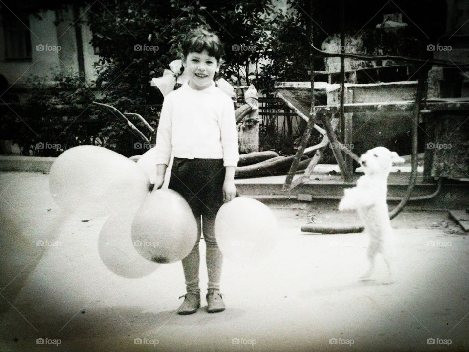 Девочка с шариками и танцующей собакой.
