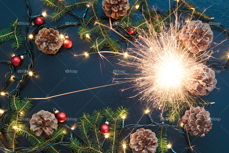 Sparklers. Christmas decoration with sparkler, lights and pine twigs