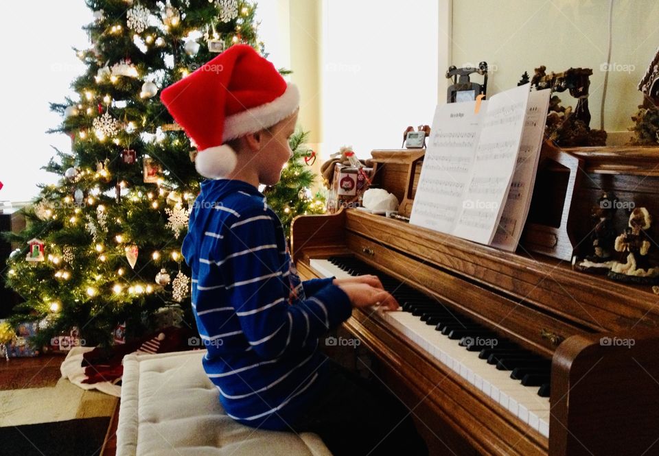 Young boy playing piano which is one of his favorite hobbies which is especially fun at Christmas time!! 