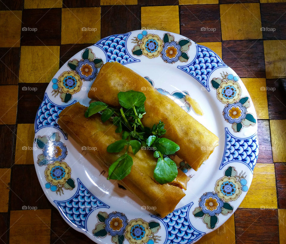 A Couple of Spring Rolls with some green leaves