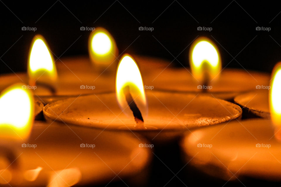 Fotografia enfocada a unas velas enfocando una y desenfocando las demas con un fondo oscuro