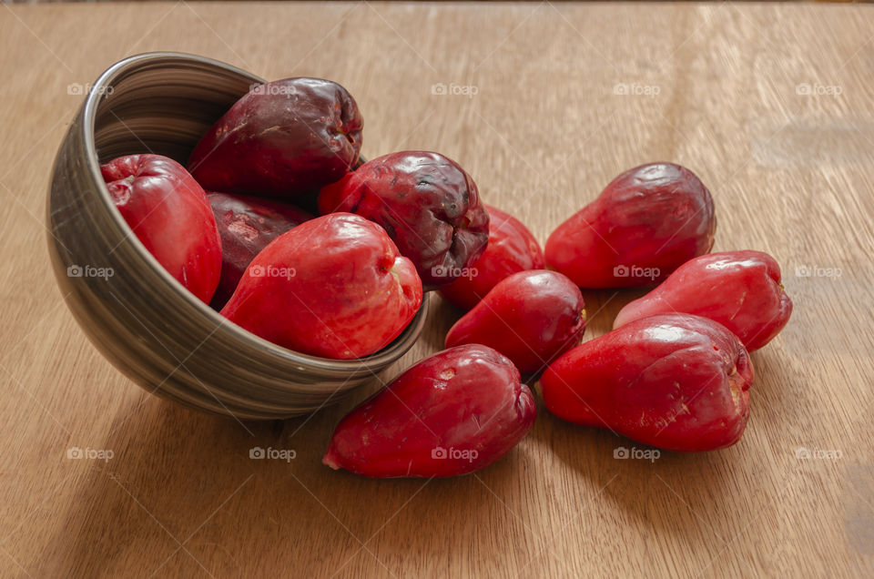 Otaheite Apples Spill From Brown Stipe Bowl On Table