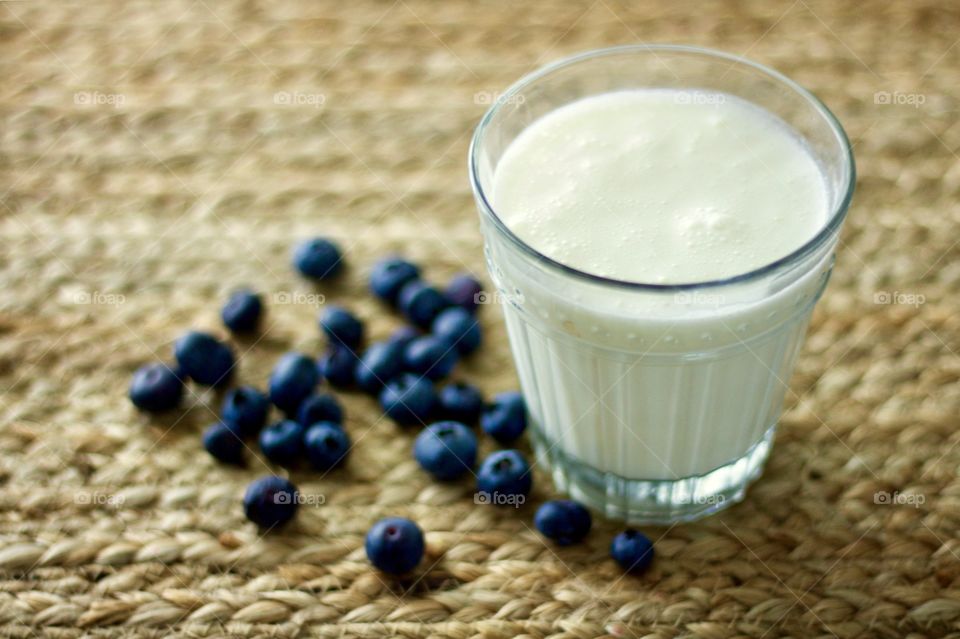 Dairy kefir in a vintage glass with blueberries on a natural fiber woven surface