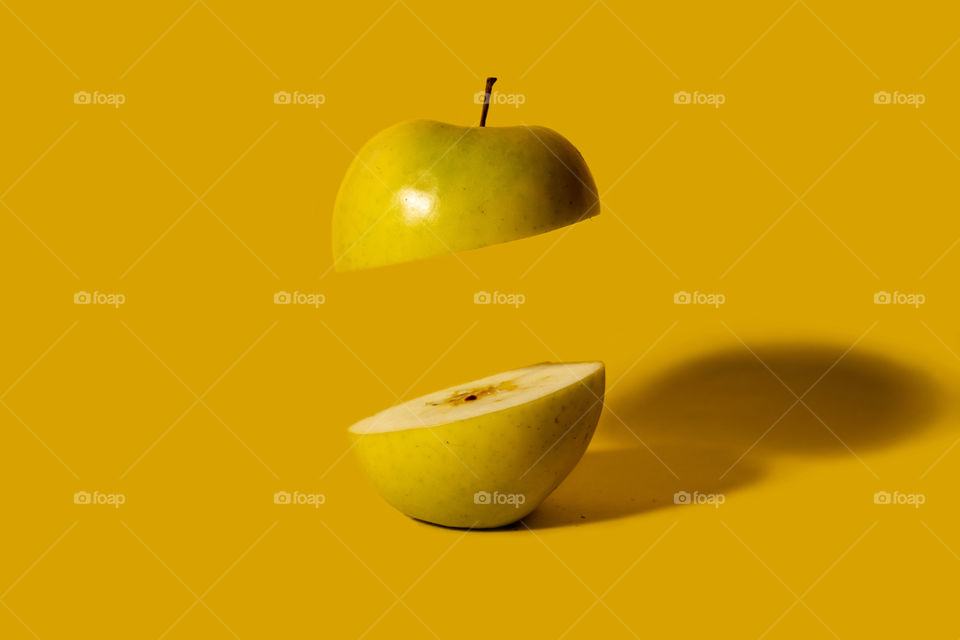 Apple sliced on half with one floating half.Creative food concept