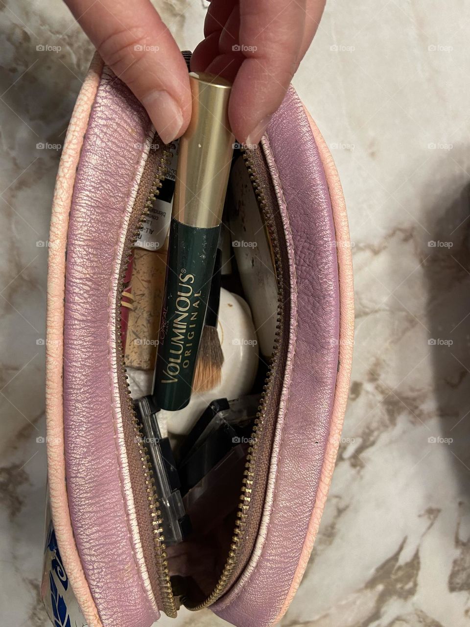 Putting my favorite L’Oréal Voluminous Mascara in Deep Green in my makeup bag, which also contains foundation, makeup brushes, a compact and eye shadows. The bag is from Box Lunch, which partners with Feeding America to get food to people in need. 